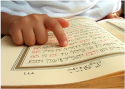 An open Rahmani Qaida book with Arabic letters and vowel marks